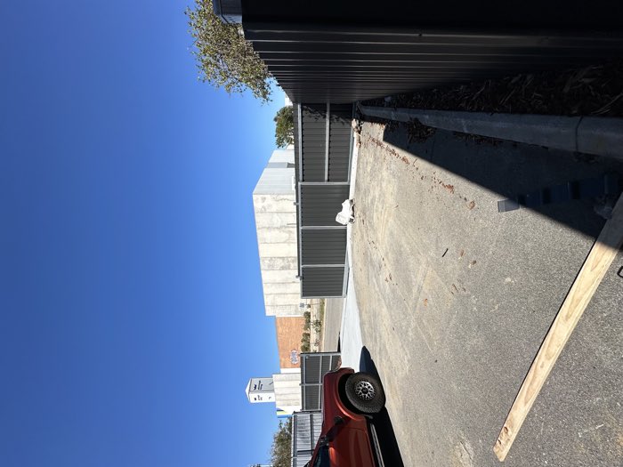 Colorbond boundary fencing and gates along a driveway
