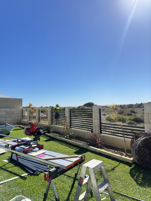 Aluminium slat fencing between limestone piers on a coastal block